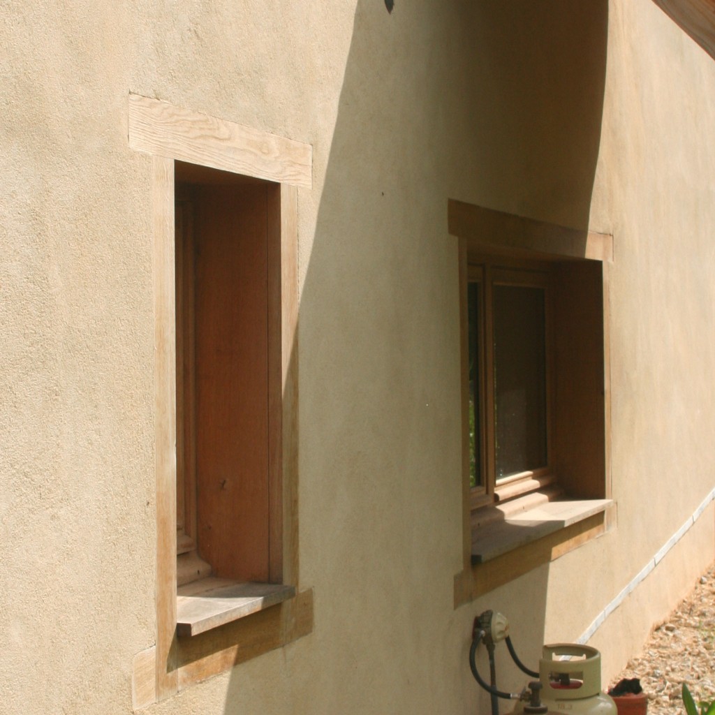 Enduit extérieur chaux aérienne et encadrements de fenêtre en chêne sur enduit isolant chaux-chanvre, en rénovation écologique d'une grange en Aveyron, par Pieds-Nus Habitat